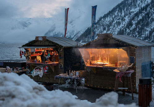 Landweihnacht beim Kräuterhüttl An der Schiffsanlegestelle Scholastika in Achenkirch am Achensee locken hell erleuchtete Marktstände mit Kunsthandwerk zur Landweihnacht. /// The Christmas market on the Scholastika pier in Achenkirch am Achensee attracts visitors with brightly lit market stalls selling artisan wares.