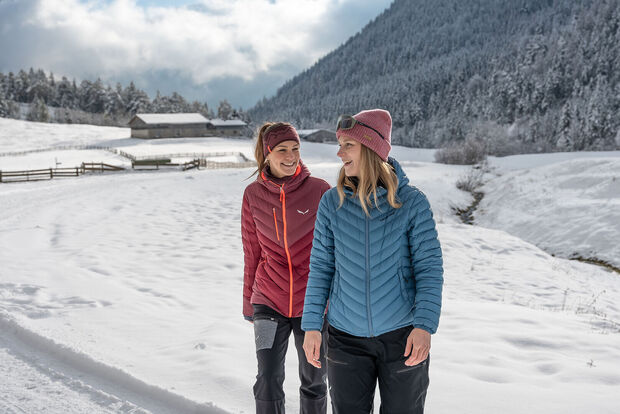 Zwei Freundinnen unternehmen bei herrlichem Wetter eine Winterwanderung im Gerntal im Naturpark Karwendel.
