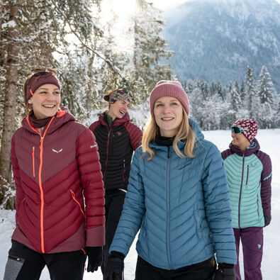 Eine Gruppe Freundinnen unternimmt bei herrlichem Wetter eine Winterwanderung im Gerntal im Naturpark Karwendel.