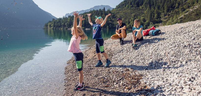 Eine Familie erkundet den Gaisalmsteig bei strahlendem Wetter und lässt sich von der Naturlandschaft verzaubern.