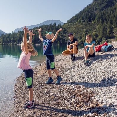 Eine Familie erkundet den Gaisalmsteig bei strahlendem Wetter und lässt sich von der Naturlandschaft verzaubern.