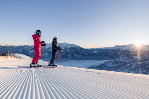 Two skiers enjoy a day of skiing in brilliant sunshine in the Hochalmlifte Christlum ski area in Achenkirch am Achensee.