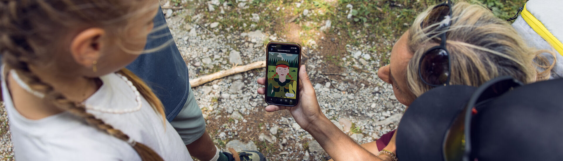 Eine Familie orientiert sich mit der App am Wunderweg am Achensee