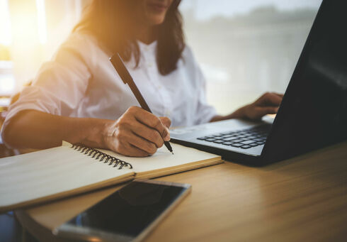 This photo captures a woman working from home on her laptop.
