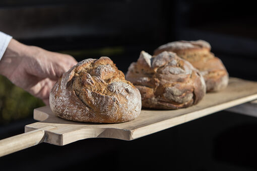 In vierter Generation führt Alexander Adler die Bäckerei Adler in Achenkirch. In diesem Bild werden die Brote im Holzofen gebacken.