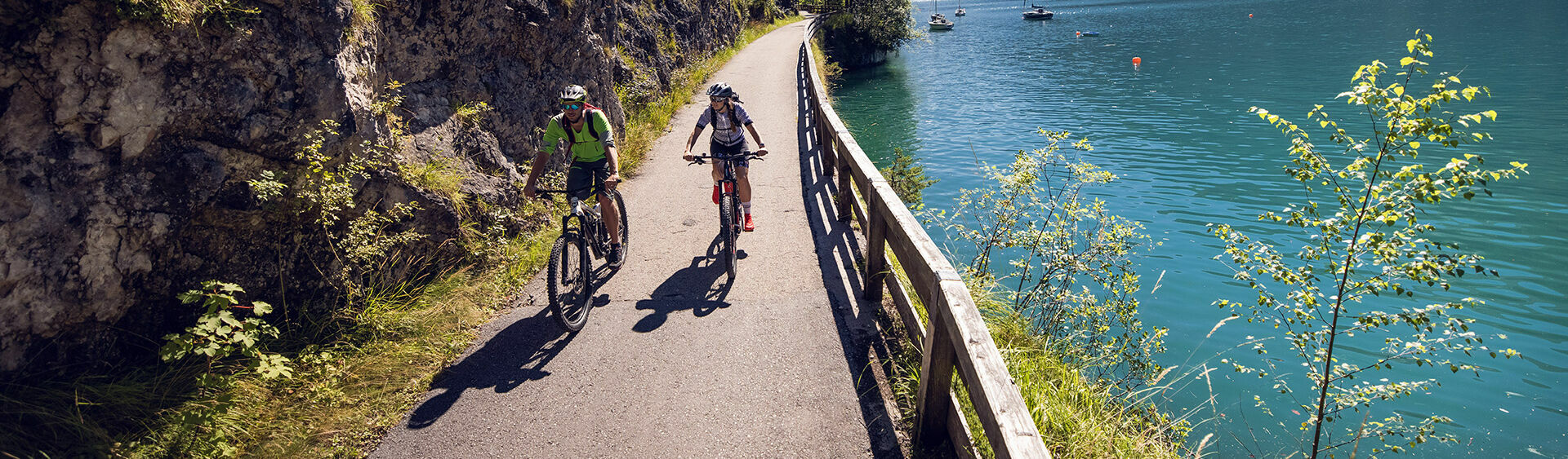 Pleasure cyclists riding on the cycle path along the lakeside in Achenkirch am Achensee.