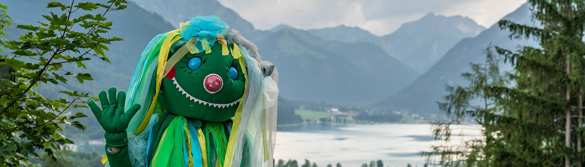 Das Maskottchen Wusel Wassergeist lächelt fröhlich in die Kamera.