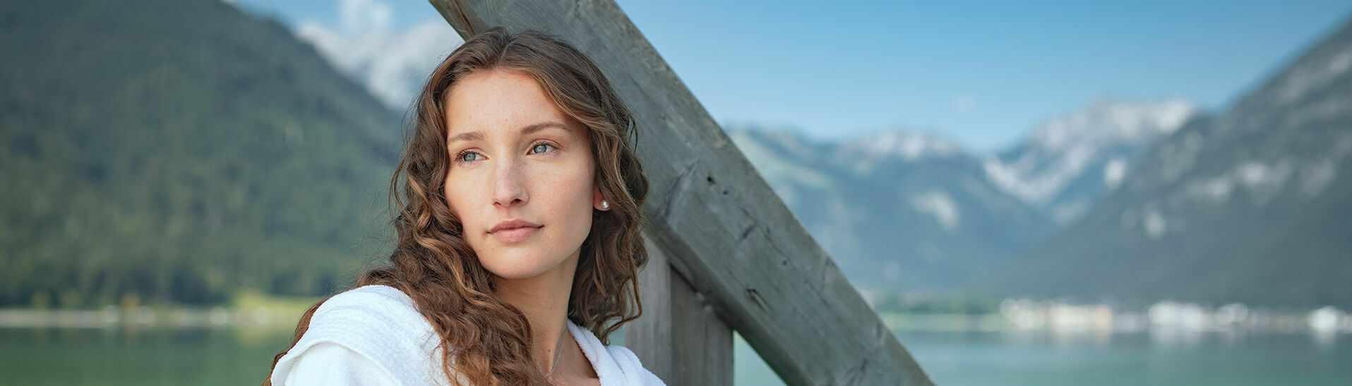 Im Bademantel am Steg des SEE-Bades in Maurach am Achensee, umringt von wunderschöner Naturlandschaft, Genussmomente erleben.