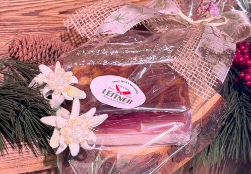Tiroler Genussmoment Ein Geschenksbrett der Metzgerei Leitner mit Speck und Würsten