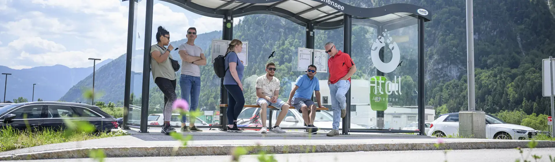 A group of people waiting for the next bus at the bus stop of the Atoll Achensee.