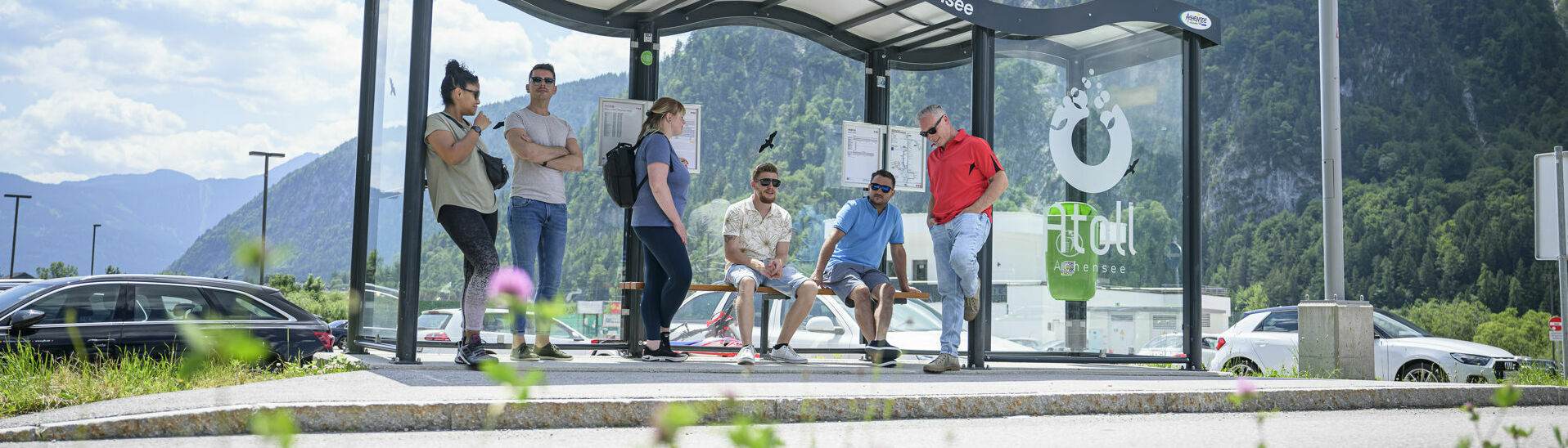 A group of people waiting for the next bus at the bus stop of the Atoll Achensee.}