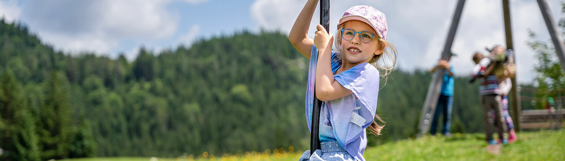 Kinder genießen den Spielplatz in Steinberg am Rofan inmitten schöner Blumenwiese.
