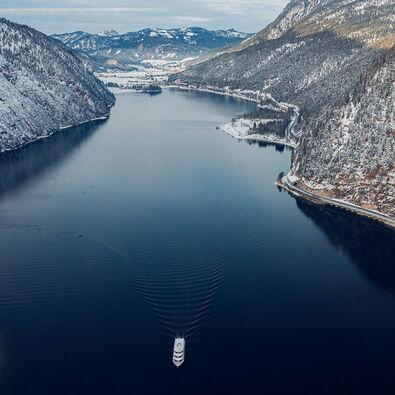 View of Lake Achensee and one of the Achensee ships in winter, the village of Pertisau and the snow-covered Karwendel mountains.