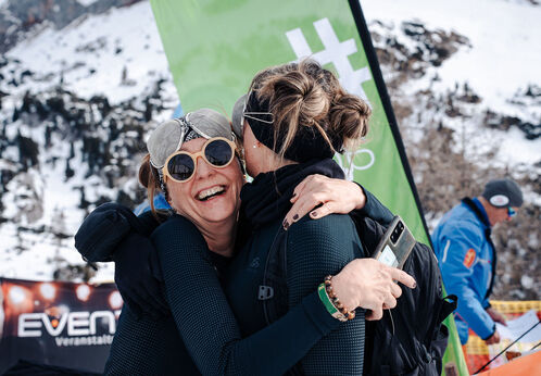 Achensee Skitourenspaß Zwei Frauen fallen sich beim Achensee Xtreme Skitourenspaß in die Arme. Im Hintergrund das Rofan.