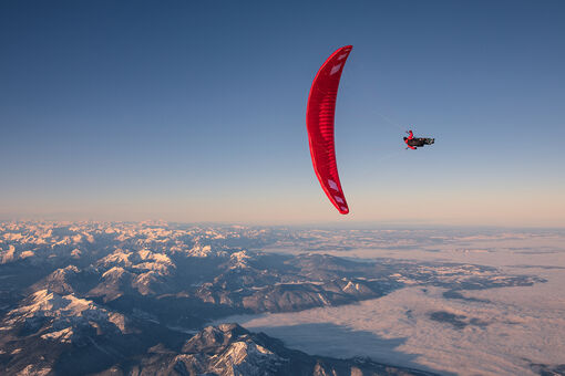 Gleitschirmflieger Mike Küng bei seinem "Head Over"-Sprung aus 7100 Metern aus einem Heißluftballon hoch über den Achensee.