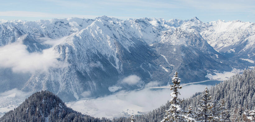 Der Blick vom Rofangebirge auf die verschneite Region Achensee und den Naturpark Karwendel.