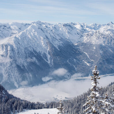 Der Blick vom Rofangebirge auf die verschneite Region Achensee und den Naturpark Karwendel.