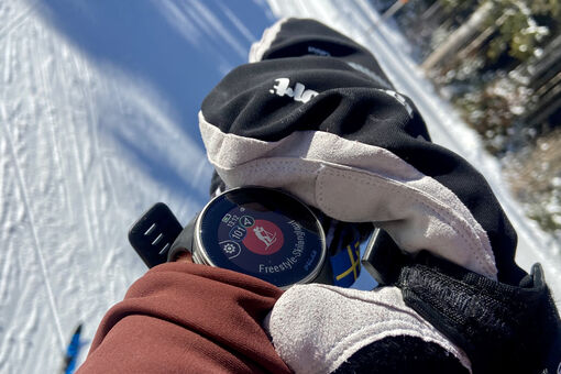 A cross-country skier starts his sports watch to record his run.