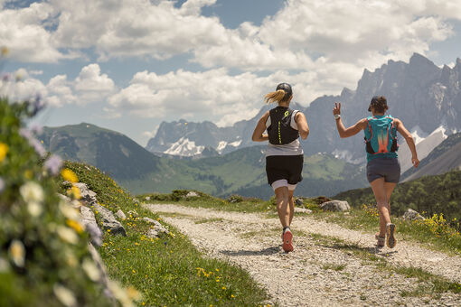 Trailrunner trainieren auf einer Forstsraße im Naturpark Karwendel in wunderschöner Umgebung.