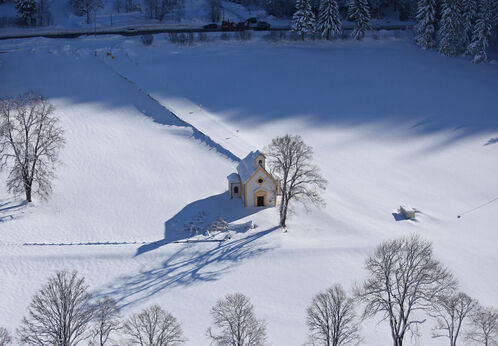 The neo-Gothic chapel Seehofkapelle is in Achenkirch am Achensee. There is fresh snow in the picture.
