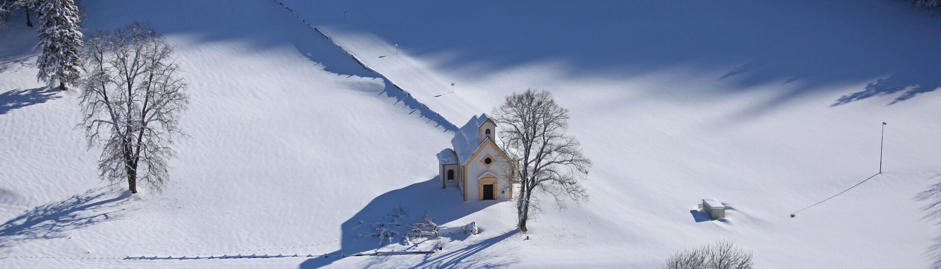 Die Seehofkapelle, die sich durch ihren neugotischen Stil auszeichnet, befindet sich in Achenkirch am Achensee. Am Bild liegt Neuschnee.