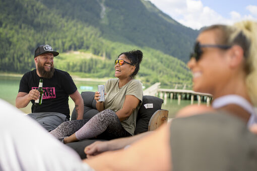 Freunde genießen ihre Freizeit bei einem kühlen Getränk in der BEACH-Bar in Maurach am Achensee.