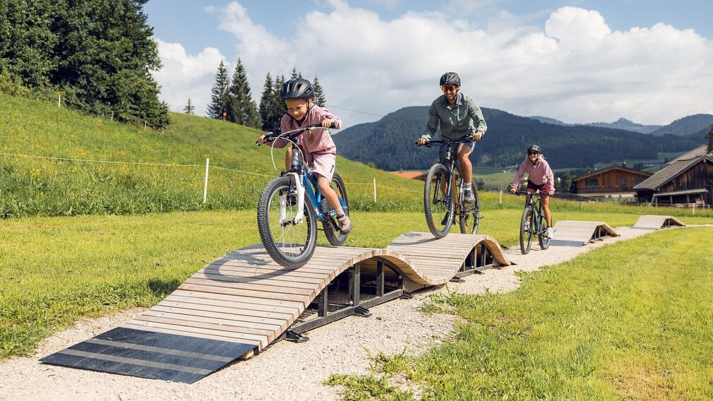 Zwei Kinder trainieren ihre Fahrtechnik am Pumptrack in Achenkirch.
