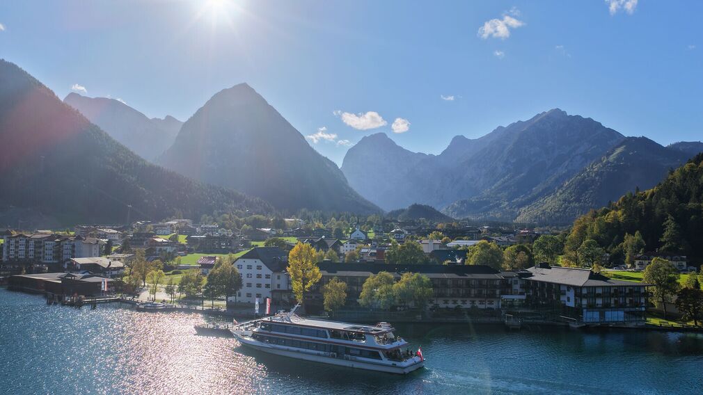 Herbstlicher Blick auf Pertisau am Achensee mit der MS Tirol der Achenseeschifffahrt und dem Karwendelgebirge Mitte Oktober.