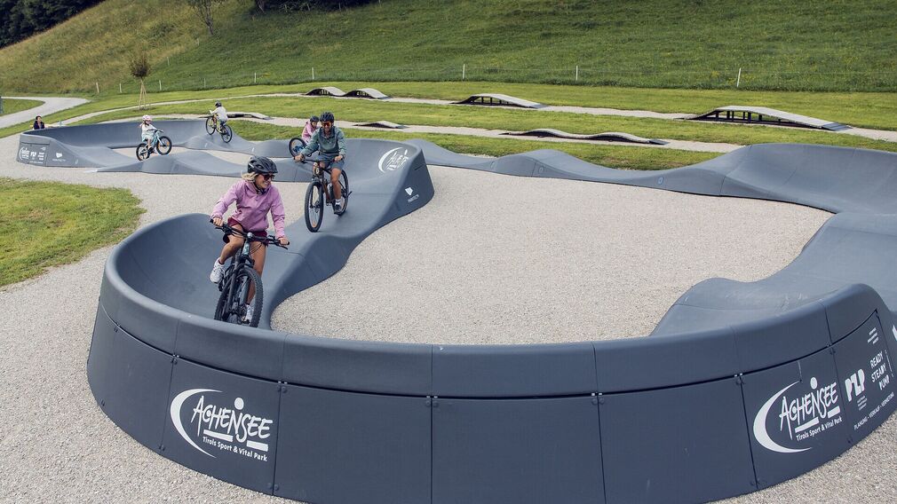 Zwei Kinder trainieren ihre Fahrtechnik am Pumptrack in Achenkirch.