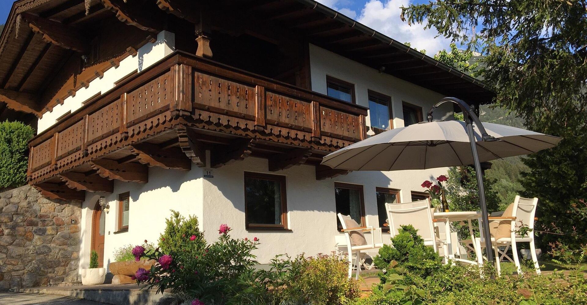 Hausansicht mit Eingang und Garten mit Terrasse