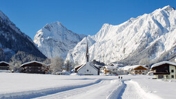 Dorfloipe in Pertisau mit der Pfarrkirche Pertisau und dem Karwendelgebirge im Hintergrund