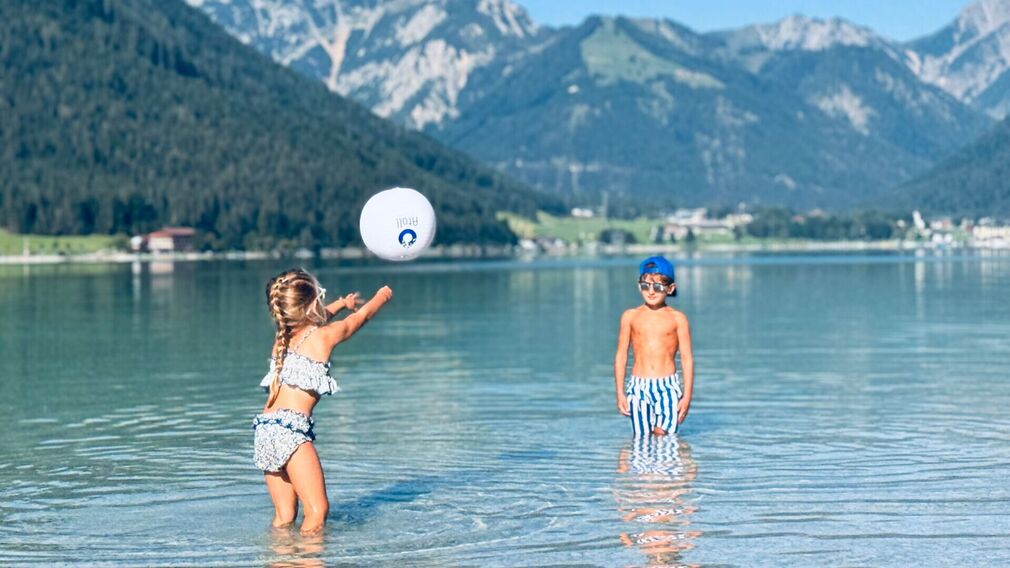 Zwei Kinder genießen das seichte Wasser im SEE-Bad im Atoll Achensee.